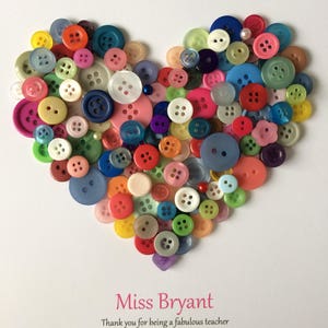 May include: A heart-shaped arrangement of colorful buttons on a white background. The text "Miss Bryant" is written in pink below the heart, followed by a thank you message to a teacher.