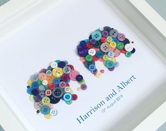 Puede incluir: Una obra de arte enmarcada con dos elefantes hechos de botones coloridos. Los elefantes se miran y el texto "Harrison and Albert 10th August 2018" está escrito debajo.