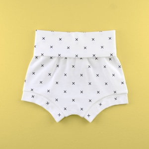 May include: White baby bloomers with a black and white criss-cross pattern.