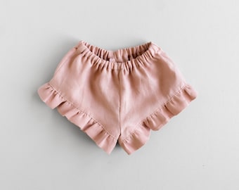 Puede incluir: Un pantalón corto de lino rosa polvoriento con un dobladillo con volantes.