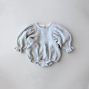 May include: A blue and white gingham baby onesie with puffed sleeves and a round neckline.
