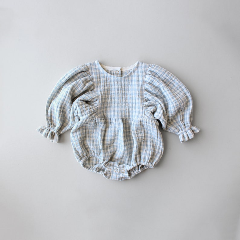 May include: A blue and white gingham baby onesie with puffed sleeves and a round neckline.