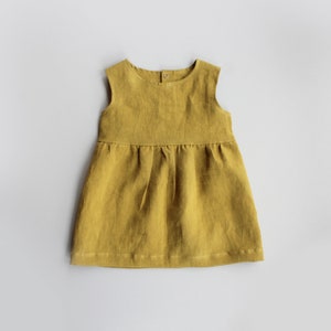 May include: A sleeveless, yellow linen dress with a gathered skirt.