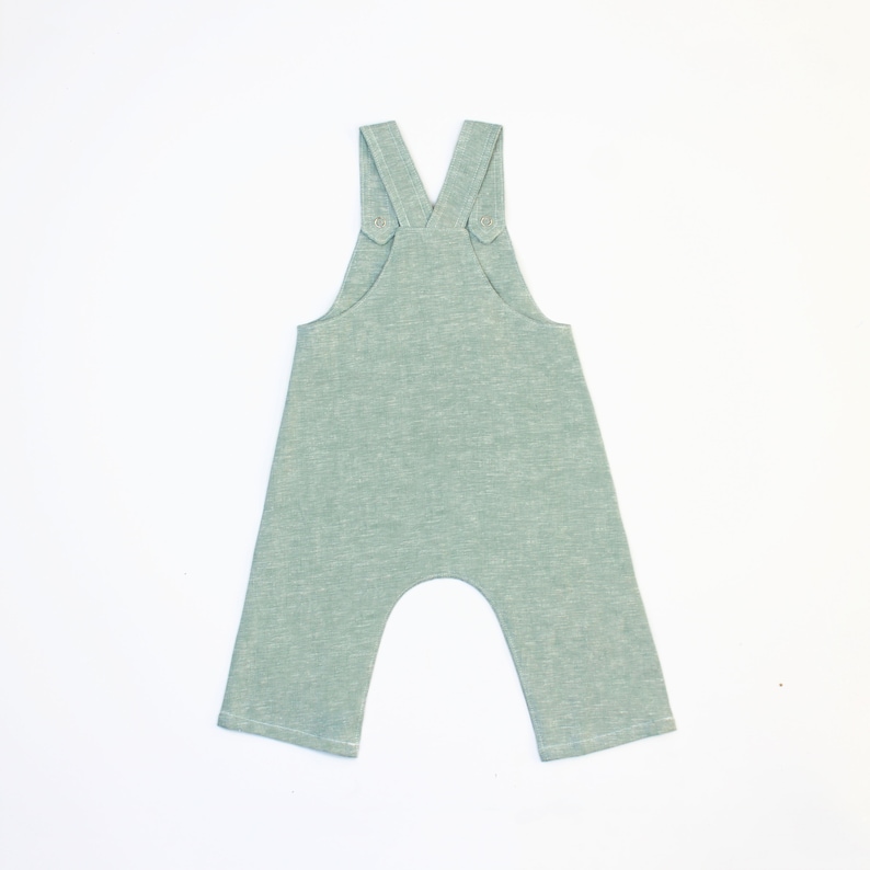 May include: A light green baby overall with adjustable straps and a relaxed fit.