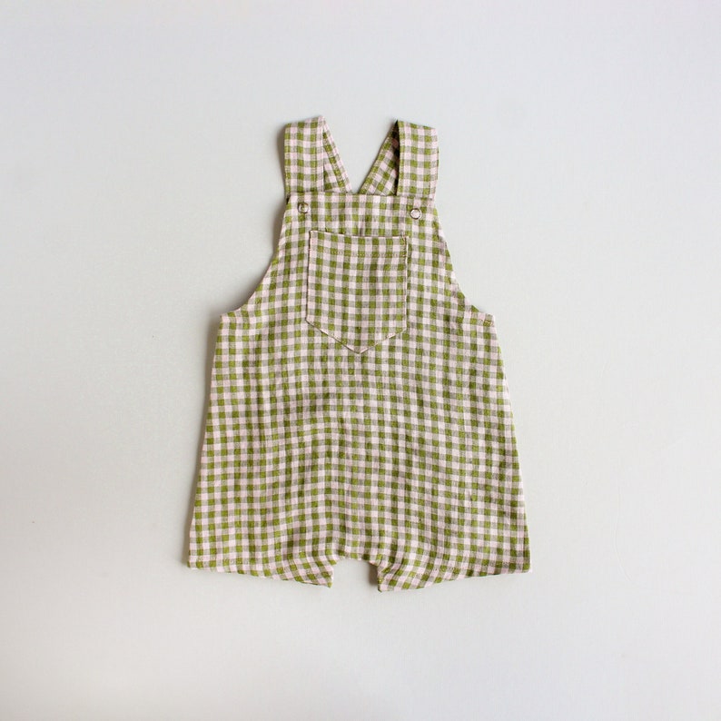 May include: Green and white gingham overall romper with a single pocket on the front.