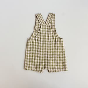 May include: Green and white gingham baby overalls with adjustable straps.
