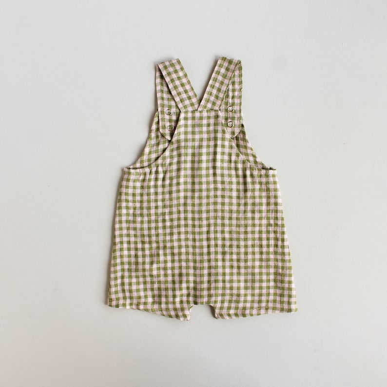 May include: Green and white gingham baby overalls with adjustable straps.