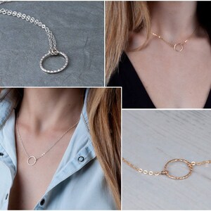 Puede incluir: Tres collares de plata y oro con un simple colgante circular. Los collares se muestran en modelos que llevan diferentes atuendos.