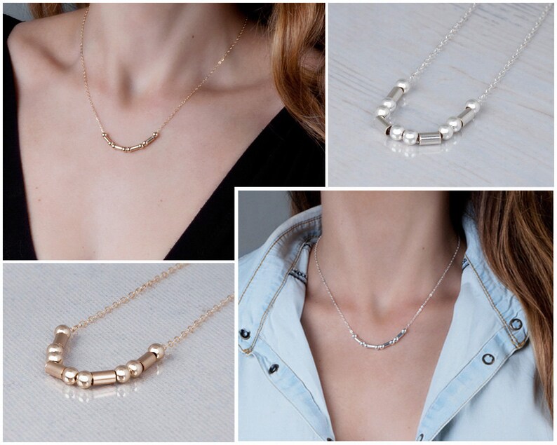 Puede incluir: Tres collares con una cadena delicada y una fila de peque&ntilde;as cuentas doradas y plateadas. Las cuentas son una mezcla de formas redondas y cil&iacute;ndricas.