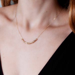 Puede incluir: Un collar de oro con una cadena delicada y una fila de peque&ntilde;as cuentas redondas.