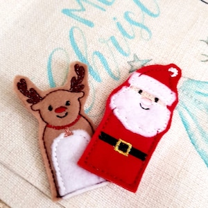 May include: Two felt Christmas finger puppets: a reindeer with brown antlers and a red nose, and Santa Claus with a white beard and red suit. The puppets are on a light-coloured background with blue text.