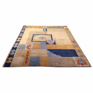 May include: A beige area rug with a geometric pattern in shades of blue, yellow, and red. The rug has a border of diamond shapes in blue and white.