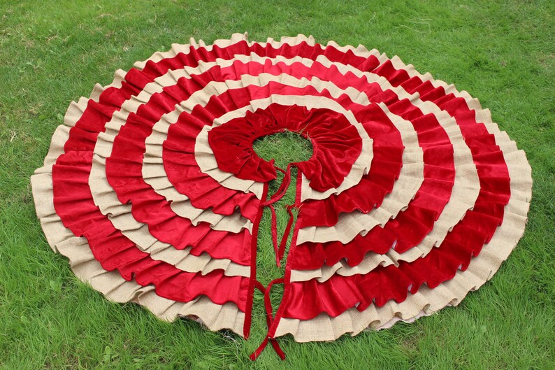 May include: A red and beige layered circle skirt with a ruffled design. The skirt is made of a soft, flowing fabric and has a simple, elegant style.