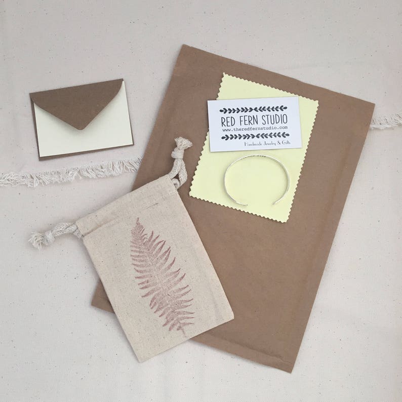 Our jewelry always comes in a sealed bag with an anti-tarnish tab and care card, along with a high quality jewelry polishing cloth, inside a natural cotton drawstring bag with a red fern on it. Included is a small notecard and envelope.