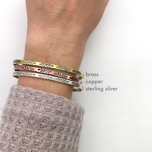 Each of our metal options: brass, copper, and sterling silver, shown on model. These stack great together or with other bracelets, or look minimal and dainty worn alone. They are comfortable to wear.