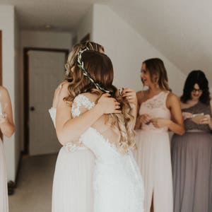 Maid of honor is hugging the bride after being gifted her personalized bracelet in a custom jewelry box. These make a meaningful gift that can be used after the wedding.