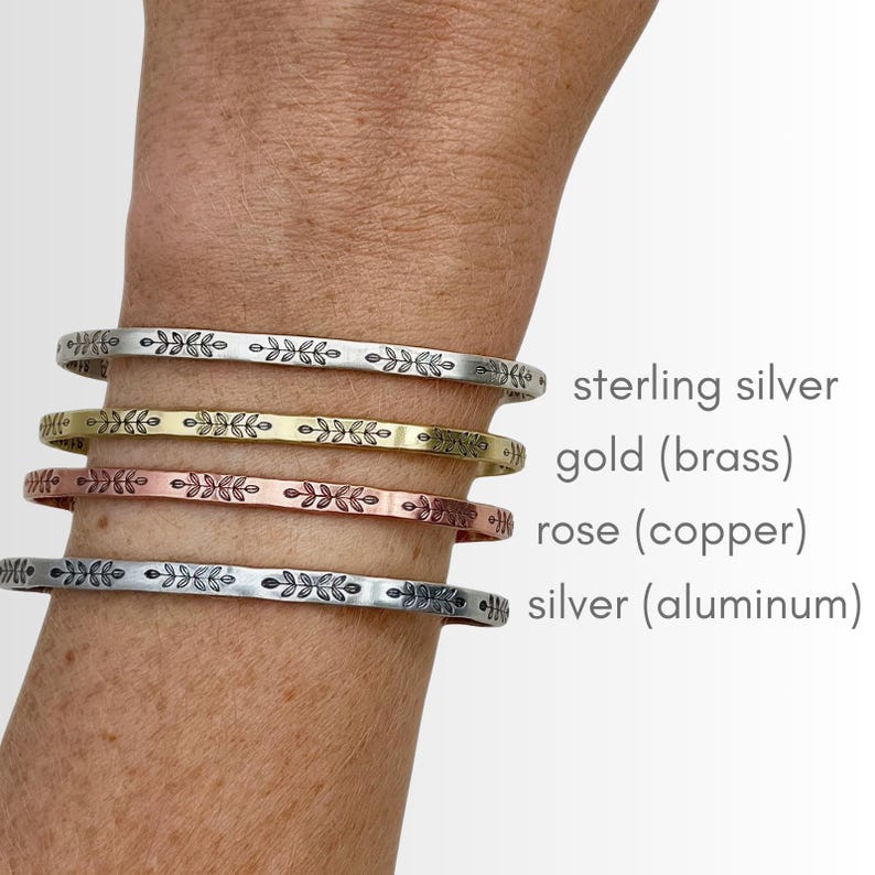 K&ouml;nnte beinhalten: Vier Metallarmreifen in Sterlingsilber, Gold (Messing), Ros&eacute; (Kupfer) und Silber (Aluminium). Jeder Armreif hat ein sich wiederholendes Blattmuster. Der Text zeigt die Metallart an.