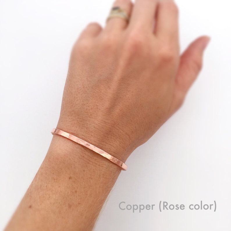 Rose toned copper cuff bracelet shown on model. These dainty, minimalist cuff bracelets stack great together or with other bracelets, or look minimal worn alone. They are comfortable to wear.