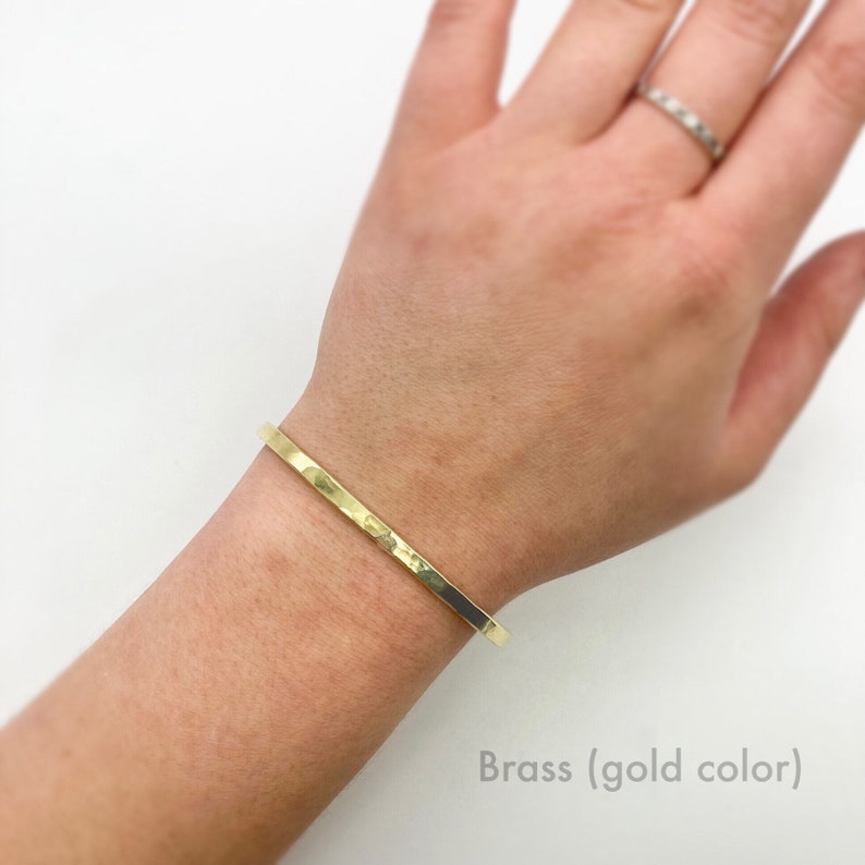 Gold toned brass cuff bracelet shown on model. These dainty, minimalist cuff bracelets stack great together or with other bracelets, or look minimal worn alone. They are comfortable to wear.