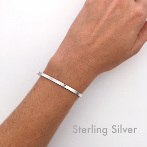 Solid sterling silver cuff bracelet shown on model. These dainty, minimalist cuff bracelets stack great together or with other bracelets, or look minimal worn alone. They are comfortable to wear.