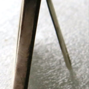 May include: Silver picture frame with a stand on the back. The frame is made of metal and has a polished finish.