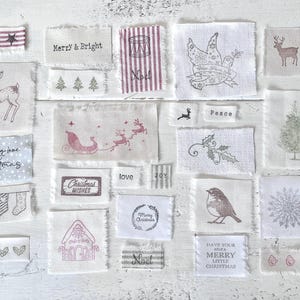 May include: A selection of small fabric patches featuring festive Christmas designs and text. The patches display images of reindeer, a Christmas tree, a sleigh, and phrases such as "Merry & Bright," "Christmas Wishes," and "Have Yourself a Merry Little Christmas."
