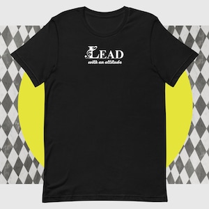 May include: Black t-shirt with the white text "LEAD with an attitude." The word "LEAD" features a musical note symbol. The shirt is a classic crew neck style.