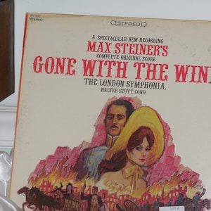 May include: A vintage vinyl record album cover featuring a red and white illustration of a burning city with a man and woman in the foreground. The album title is "Gone With The Wind" by Max Steiner's Complete Original Score. The London Symphony Orchestra is credited, conducted by Walter Stott.