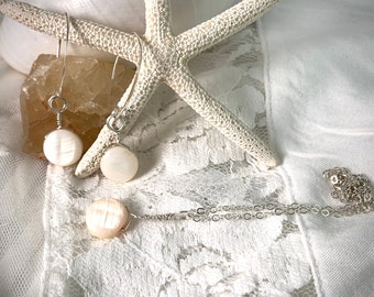 May include: A set of white pearl earrings and a necklace with a silver chain. The earrings are simple and elegant, with a single pearl on each earring. The necklace is also simple, with a single pearl pendant.
