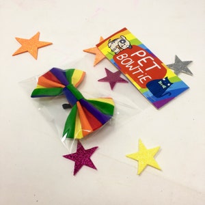 May include: Rainbow striped bow tie for pets, packaged in a clear plastic bag with a colourful tag that says "Pet Bowtie".