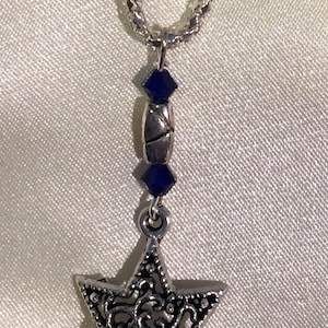May include: A silver chain necklace with a silver Star of David pendant and blue crystal accents.