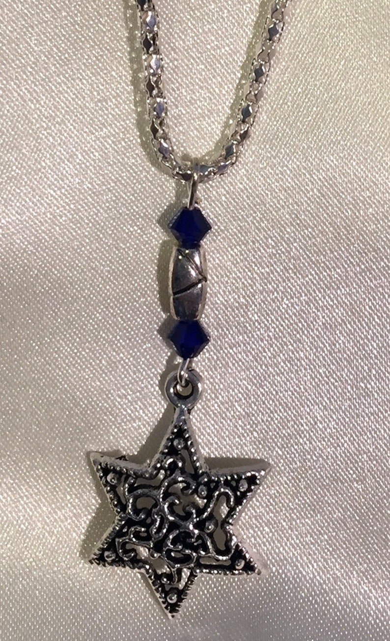 May include: A silver chain necklace with a silver Star of David pendant and blue crystal accents.