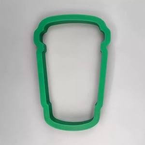 May include: Green plastic cookie cutter shaped like a coffee cup.