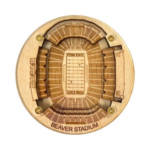 Puede incluir: Un posavasos de madera con una vista aérea grabada con láser del Beaver Stadium, hogar del equipo de fútbol americano de los Nittany Lions de Penn State. El posavasos tiene las palabras "Penn State" y "Beaver Stadium".