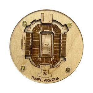 May include: A wooden circular coaster with a laser-cut design of Sun Devil Stadium, home of the Arizona State Sun Devils football team. The coaster features the words "Arizona State" and "Sun Devils" along with the stadium's location, "Tempe, Arizona".