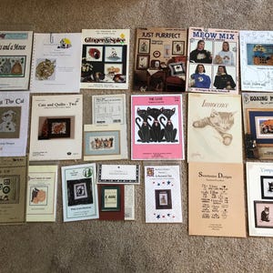 Lot of 19 counted cross stitch patterns featuring cats