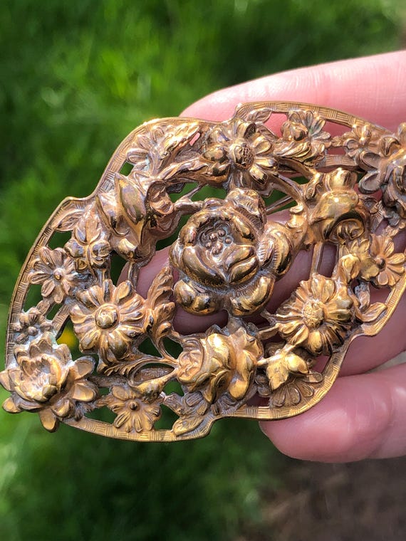 Antique brass sash pin with ornate rose design
