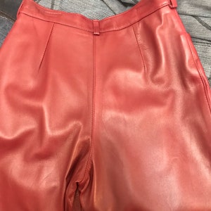 May include: A pair of burgundy leather pants with a high waist and a straight leg.