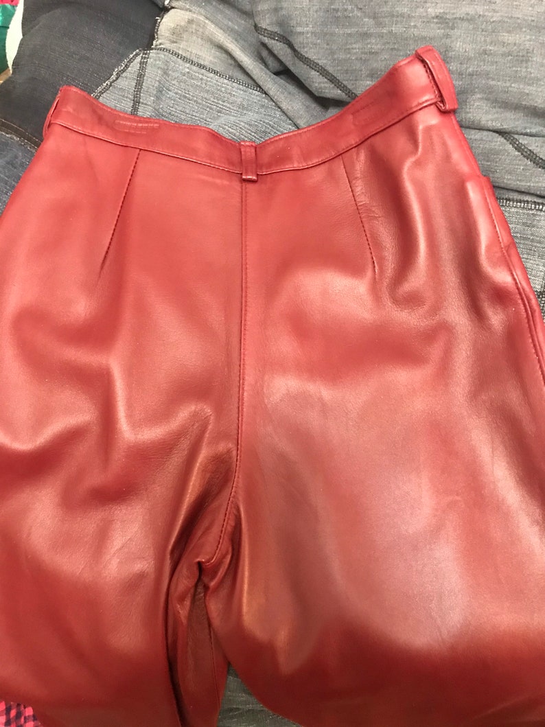 May include: A pair of burgundy leather pants with a high waist and a straight leg.