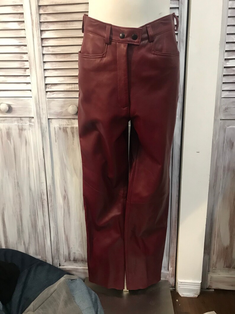 May include: A pair of burgundy leather pants with a high waist and a button fly.