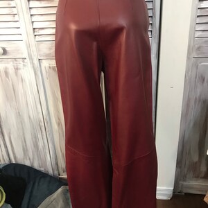 May include: A pair of burgundy leather pants with a high waist and a wide leg.