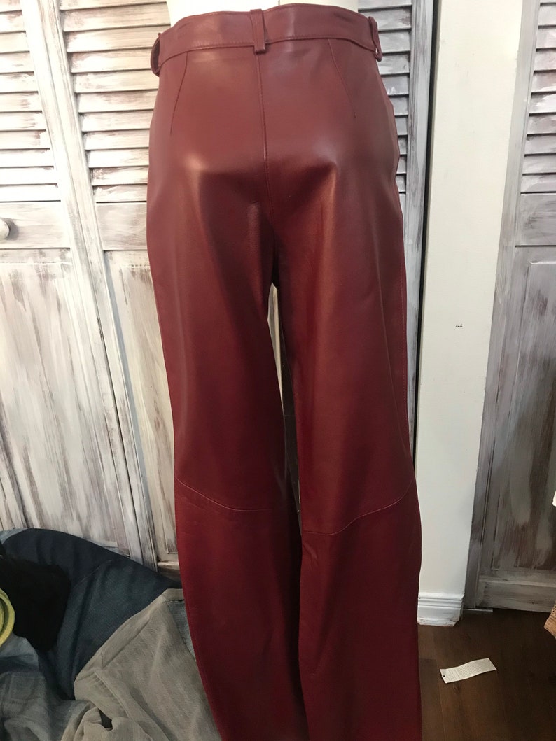 May include: A pair of burgundy leather pants with a high waist and a wide leg.