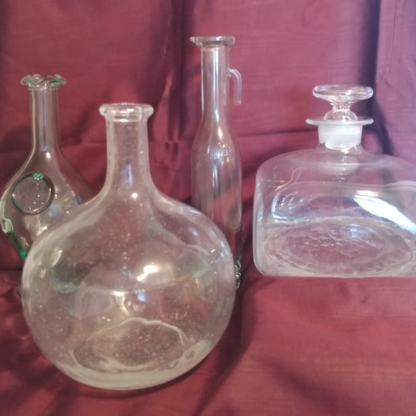 A collection of Hand blown clear glass bottles