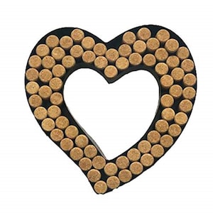 May include: A heart-shaped decorative item with a black border. The heart is filled with small, round, cork pieces. The center of the heart is open, creating a negative space. The cork pieces are a light brown color.