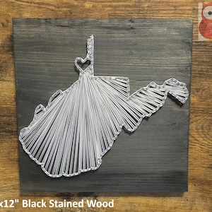 May include: A 12" x 12" black stained wood wall art piece featuring a string art design of the state of West Virginia with a heart in the center.