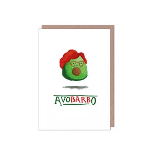 Puede incluir: Tarjeta de felicitación humorística con un personaje de aguacate dibujado con gafas y una peluca roja. El texto "AVOBARBO" es verde. La tarjeta es blanca con un borde marrón. El aguacate tiene un hueso marrón.