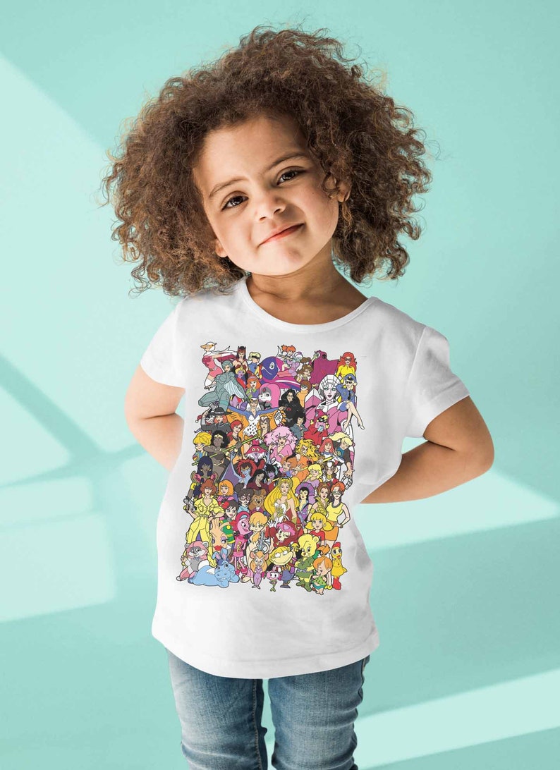 May include: A white t-shirt with a colorful graphic print of cartoon characters. The characters are all female and are from different animated shows. The shirt is being worn by a young child.