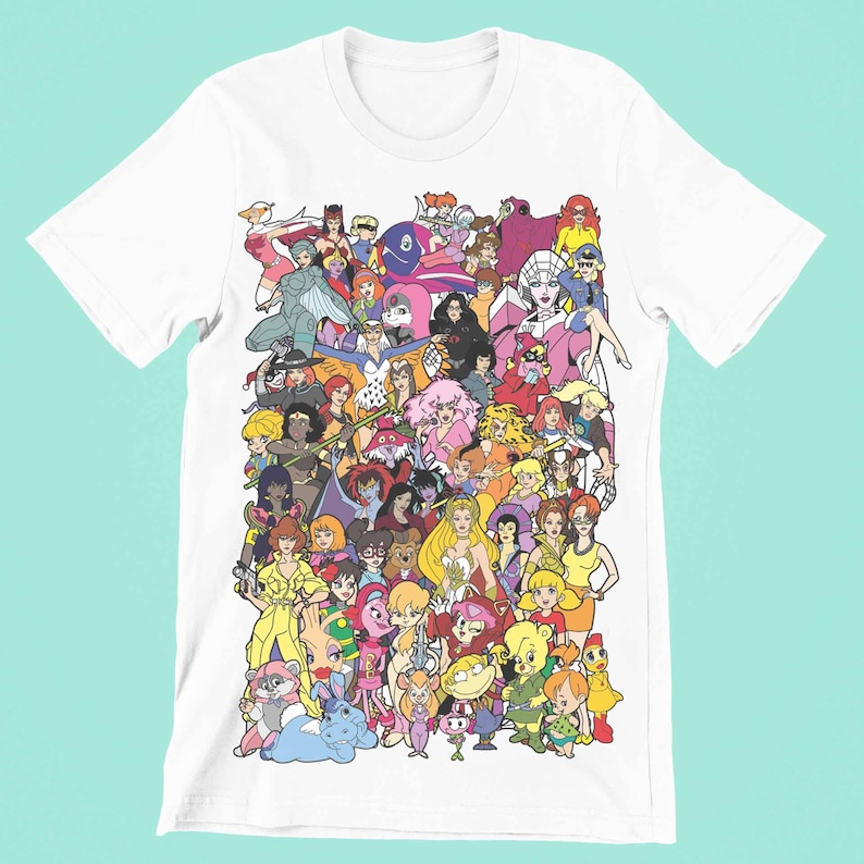 May include: White t-shirt with a colorful graphic print of cartoon female characters from various animated series. The characters are arranged in a chaotic and playful manner, creating a vibrant and nostalgic design.