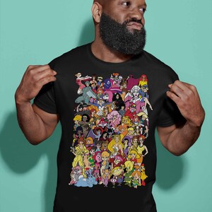 May include: A black t-shirt with a colorful graphic print of cartoon characters. The characters are all female and are arranged in a collage-like pattern.