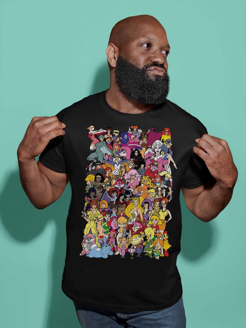 May include: A black t-shirt with a colorful graphic print of cartoon characters. The characters are all female and are arranged in a collage-like pattern.